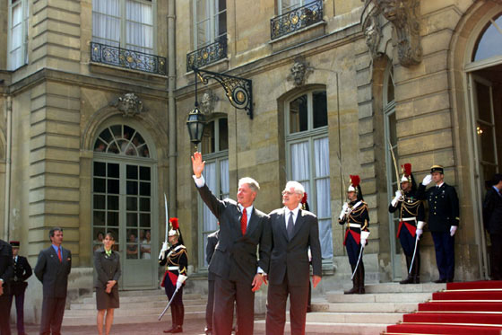 President Clinton, accompanied by French Prime Minister Lionel Jospin, waves to the crowd outside the Prime Minister's residence, Hôtel Matignon.