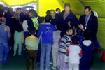Young children gather around President Clinton inside a tent at the camp.