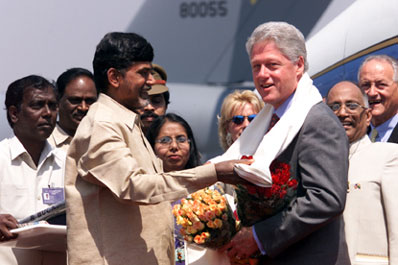 Chief Minister N. Chandrababu Naidu presents President Clinton with traditional items of greeting. Hyderabad Airport, India. 